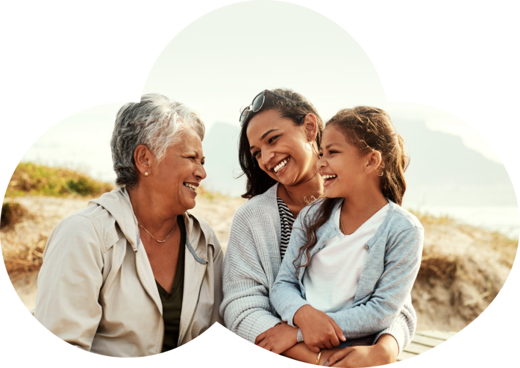 Grandmother, mother and daughter laughing together at the beach